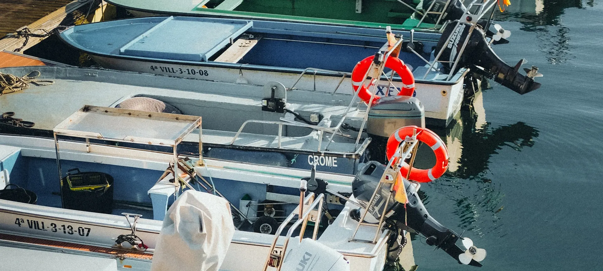 Småbåter med påhengsmotorer fortøyd ved en brygge
