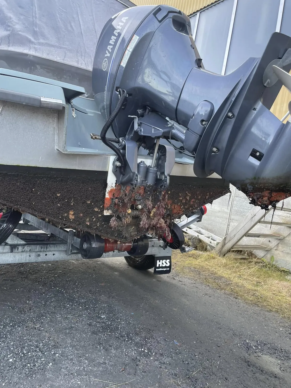 Yamaha påhengsmotor på båt på henger, med grohemning og rur på skrogbunnen
